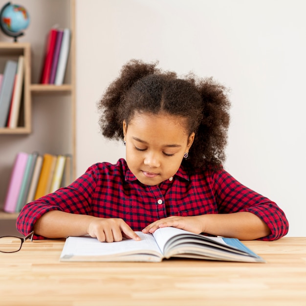 Photo gratuite vue frontale, petite fille, lecture