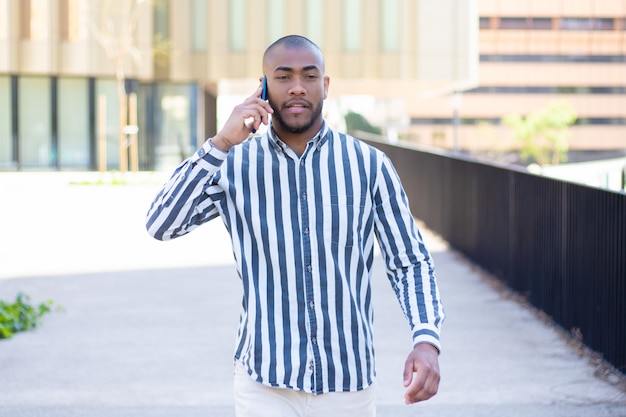 Vue frontale, de, sérieux, jeune homme, parler téléphone, pendant, promenade