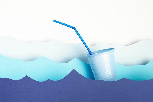 Vue frontale, de, tasse plastique, à, paille, et, papier, vagues