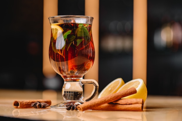 Vue frontale d'un verre de thé tonifiant au citron et à la menthe cannelle