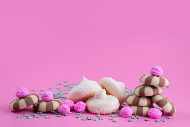 Une vue frotn cookies au chocolat avec des meringues sur un bureau rose, couleur bonbon biscuit biscuit