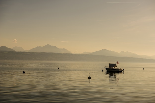 Vue grand angle d'un bateau sur l'eau entouré de montagnes