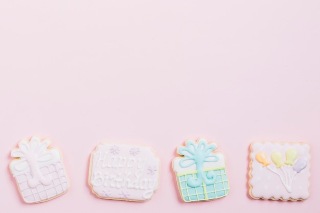 Photo gratuite vue grand angle de biscuits d'anniversaire sur fond rose