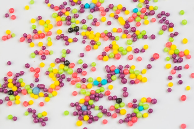 Photo gratuite vue grand angle de boules de sucre sucré colorées sur fond blanc