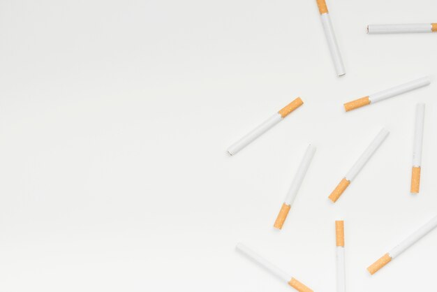 Vue grand angle de cigarettes contre la surface blanche