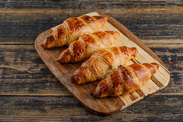 Vue grand angle croissant sur planche de bois et à découper