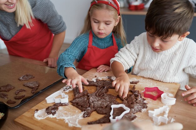 Vue grand angle des enfants découpant les cookies de pain d'épice