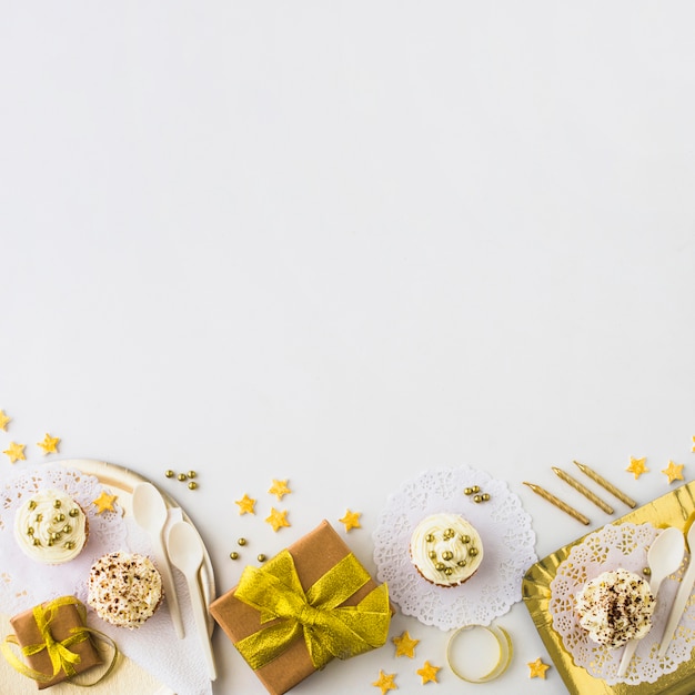 Vue grand angle de muffins et de cadeaux au bord du fond blanc