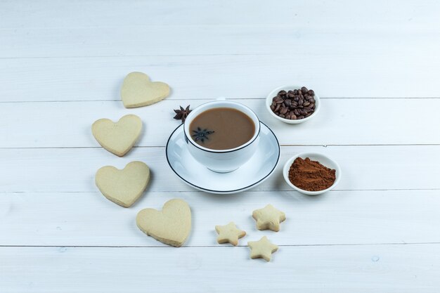 Vue grand angle tasse de café avec des biscuits, des grains de café et du café instantané sur fond de planche de bois blanc. horizontal