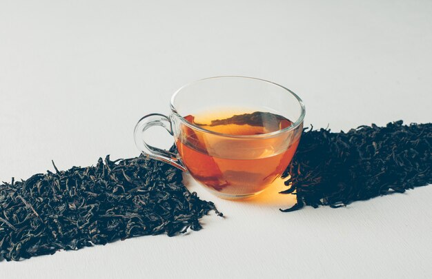 Vue grand angle sur le thé noir sous forme de ligne avec une tasse de thé