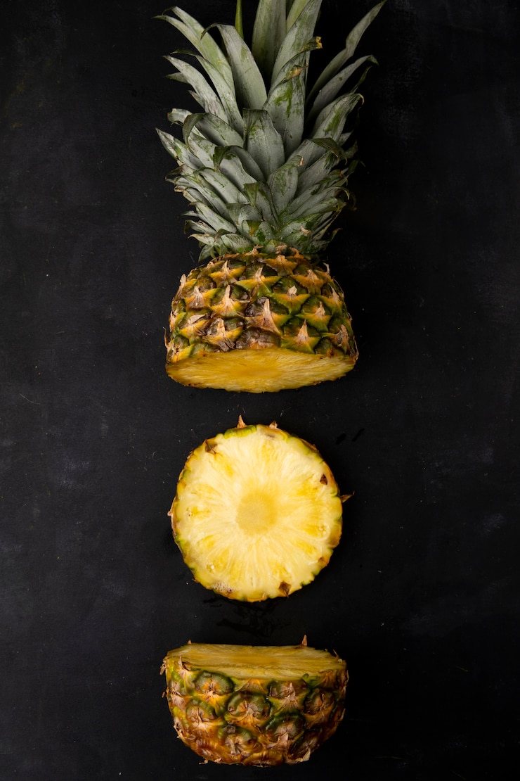 Photo gratuit vue de haut de l'ananas coupé sur surface noire