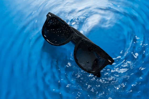 Photo gratuite vue d'en haut sur des lunettes de soleil flottant sur l'eau