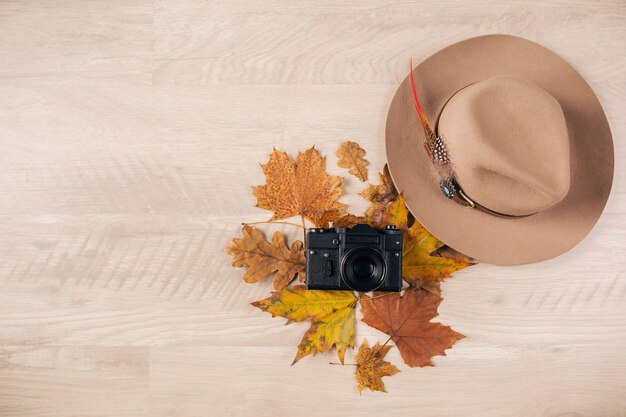 Photo gratuite vue d'en haut sur la mise à plat du style femme et accessoires, tendance de la mode des feuilles d'automne, appareil photo vintage, tenue de voyageur