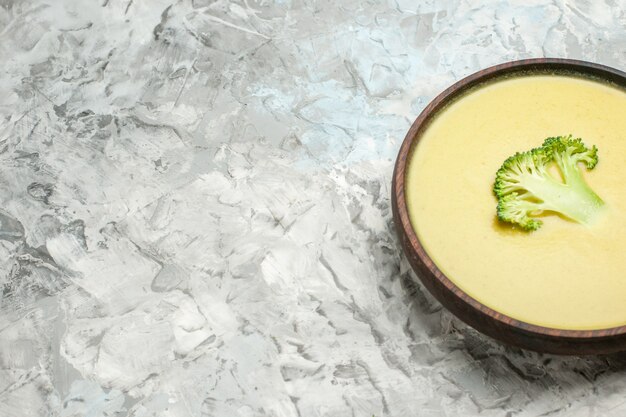 Vue horizontale de la crème de soupe de brocoli dans un bol brun sur tableau blanc