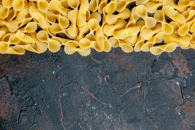 Vue horizontale des pâtes papillon sur le dessus de la table de couleurs mélangées