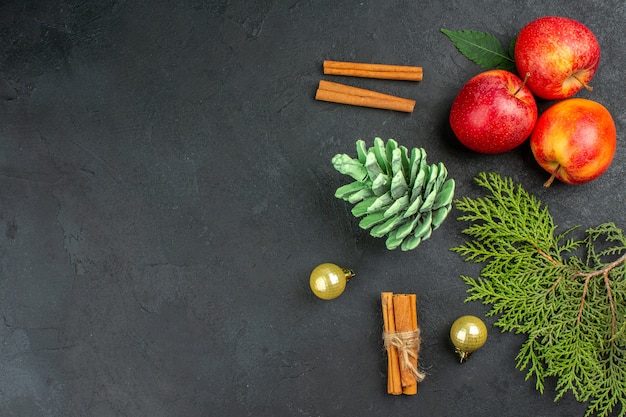 Vue horizontale des pommes fraîches, des citrons verts à la cannelle et des accessoires de décoration sur un tableau noir