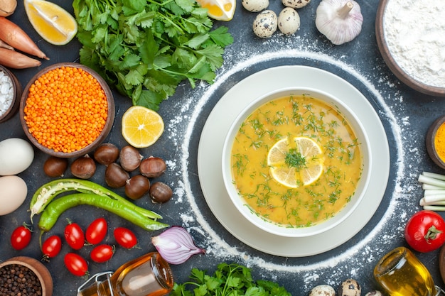 Vue horizontale d'une soupe appétissante servie avec du citron et du vert dans un bol blanc et de la farine bouteille d'huile de tomate farine de paquets verts d'oeufs sur fond noir