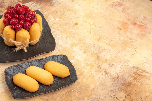 Vue horizontale de la table avec un gâteau cadeau et des biscuits pour les clients sur table de couleurs mixtes