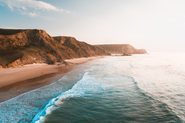 Photo gratuite vue imprenable sur l'océan et les falaises rocheuses sous le beau ciel lumineux