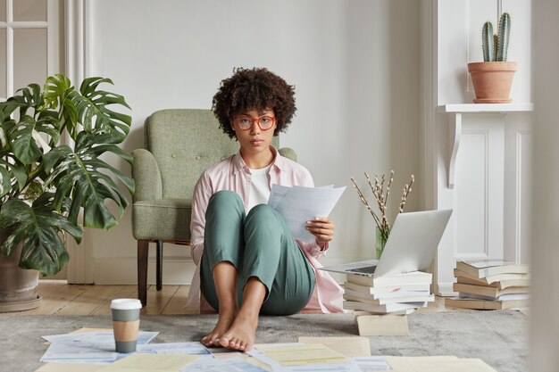 Vue intérieure d'une femme intelligente posant dans un appartement confortable