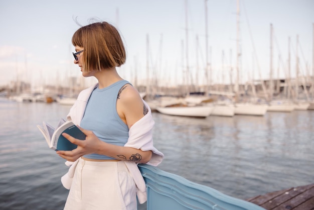 Vue de jolie femme avec un livre sur le remblai