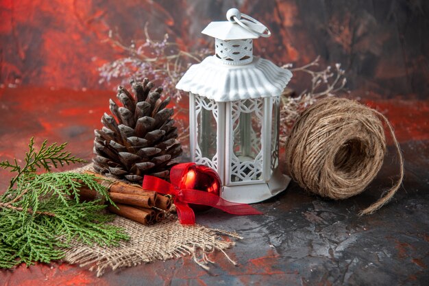 Vue latérale d'accessoires de décoration cône de conifère une boule de corde et sapin brances limes cannelle sur fond sombre