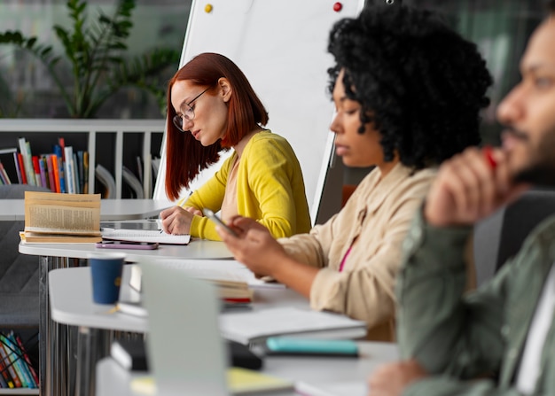 Photo gratuite vue latérale des adultes qui étudient ensemble