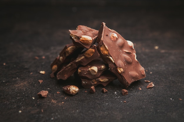 Vue latérale des amandes au chocolat sur une texture marron foncé.