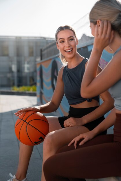 Vue latérale des amies jouant au basket