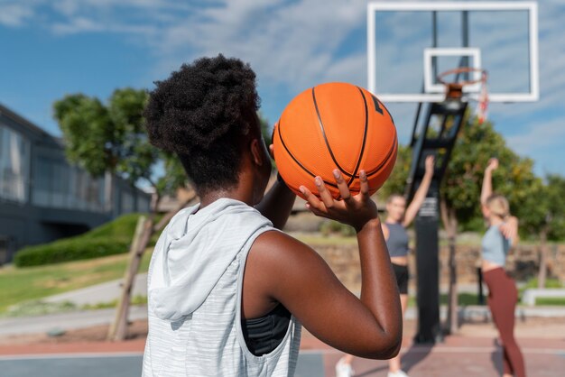 Vue latérale des amies jouant au basket