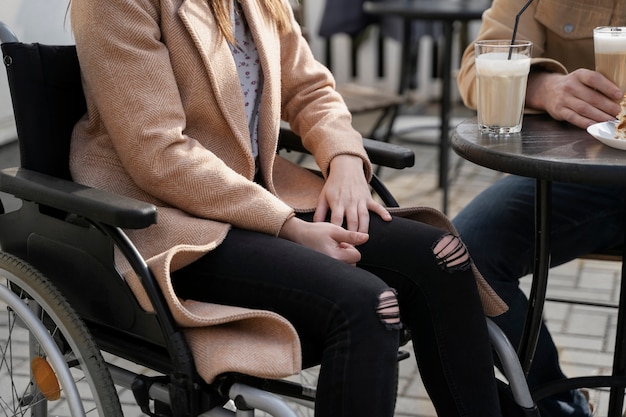 Vue latérale amis handicapés avec fauteuil roulant