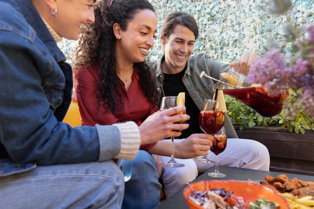 Vue latérale amis heureux avec des boissons