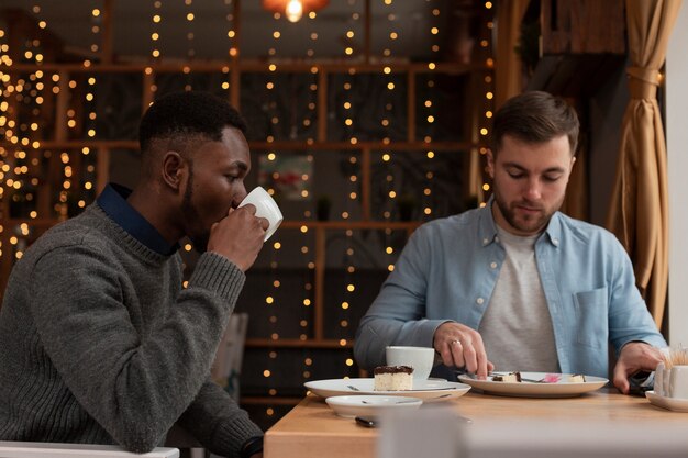 Vue latérale des amis masculins au restaurant