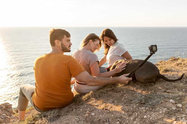 Vue latérale des amis prenant un selfie sur une côte