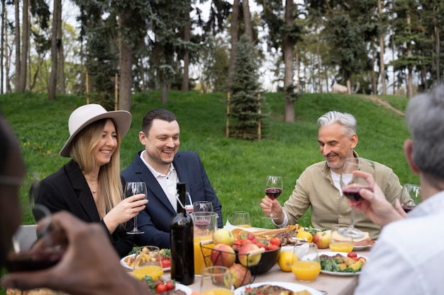 Vue latérale amis smiley faire la fête dans la nature