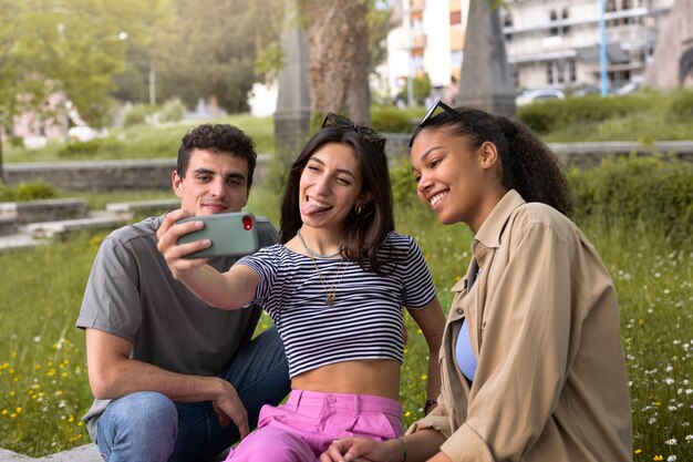 Vue latérale amis souriants prenant selfie