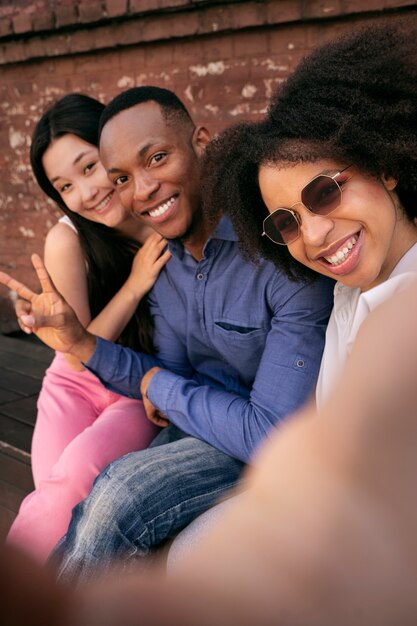 Vue latérale amis souriants prenant selfie