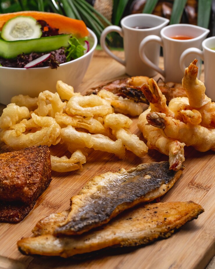 Photo gratuit vue latérale apéritifs de fruits de mer crevettes de calmar de poisson avec sauces et salade