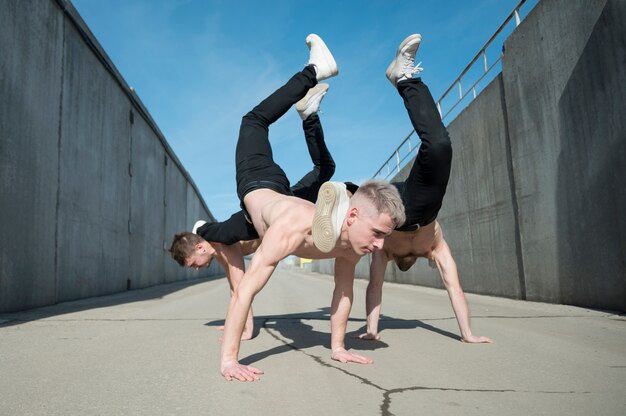 Vue latérale d'artistes hip hop torse nu dansant