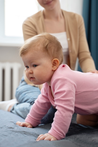 Vue latérale bébé mignon apprenant à ramper