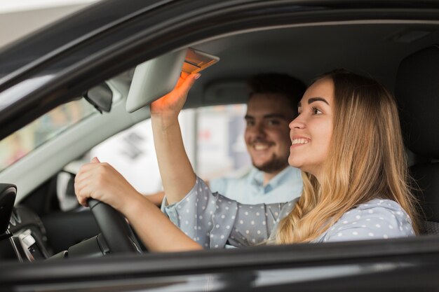 Vue latérale de la belle femme blonde en voiture