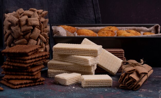 Vue latérale des biscuits au chocolat et des gaufres croustillantes sur dark