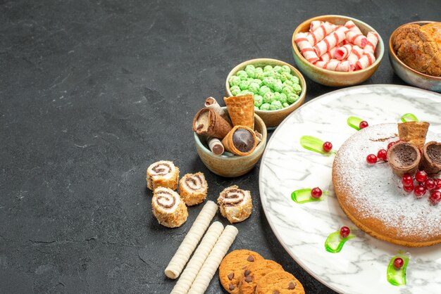 Vue latérale des bonbons un gâteau appétissant aux baies gaufres biscuits bonbons colorés