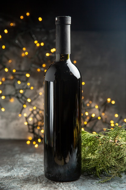 Vue latérale d'une bouteille de vin rouge pour la célébration sur fond sombre