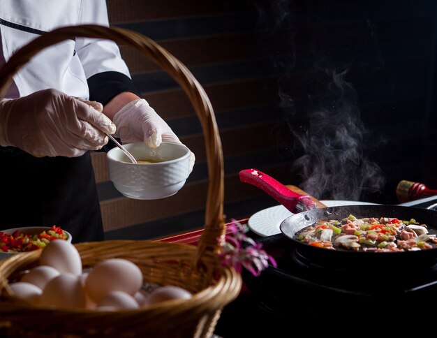 Vue latérale chef prépare un délicieux repas dans la cuisine.