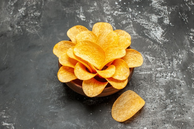 Vue latérale des chips dans un bol sur une table gris foncé