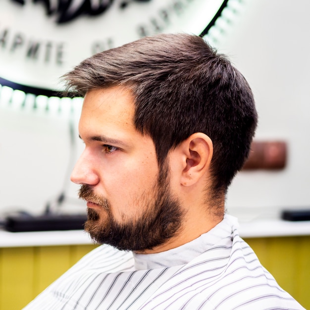 Photo gratuite vue latérale d'un client en attente d'une coupe de cheveux
