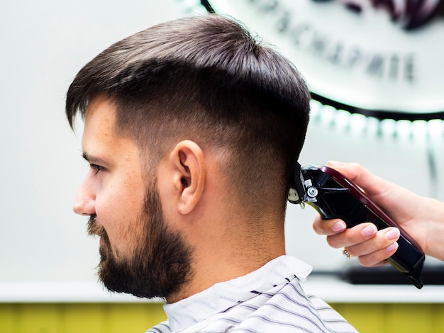 Photo gratuite vue latérale d'un client en attente d'une coupe de cheveux