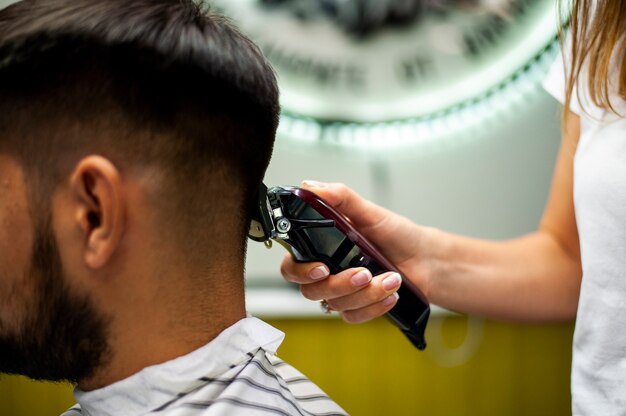 Vue latérale d'un client se faisant couper les cheveux