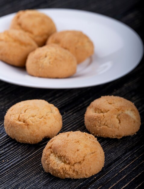 Vue latérale des cookies sur une plaque blanche sur bois